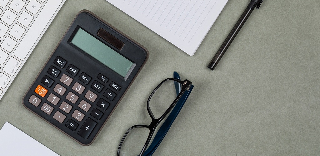 financial-concept-with-notebook-paper-pen-calculator-keyboard-glasses-grey-background-flat-lay.jpg