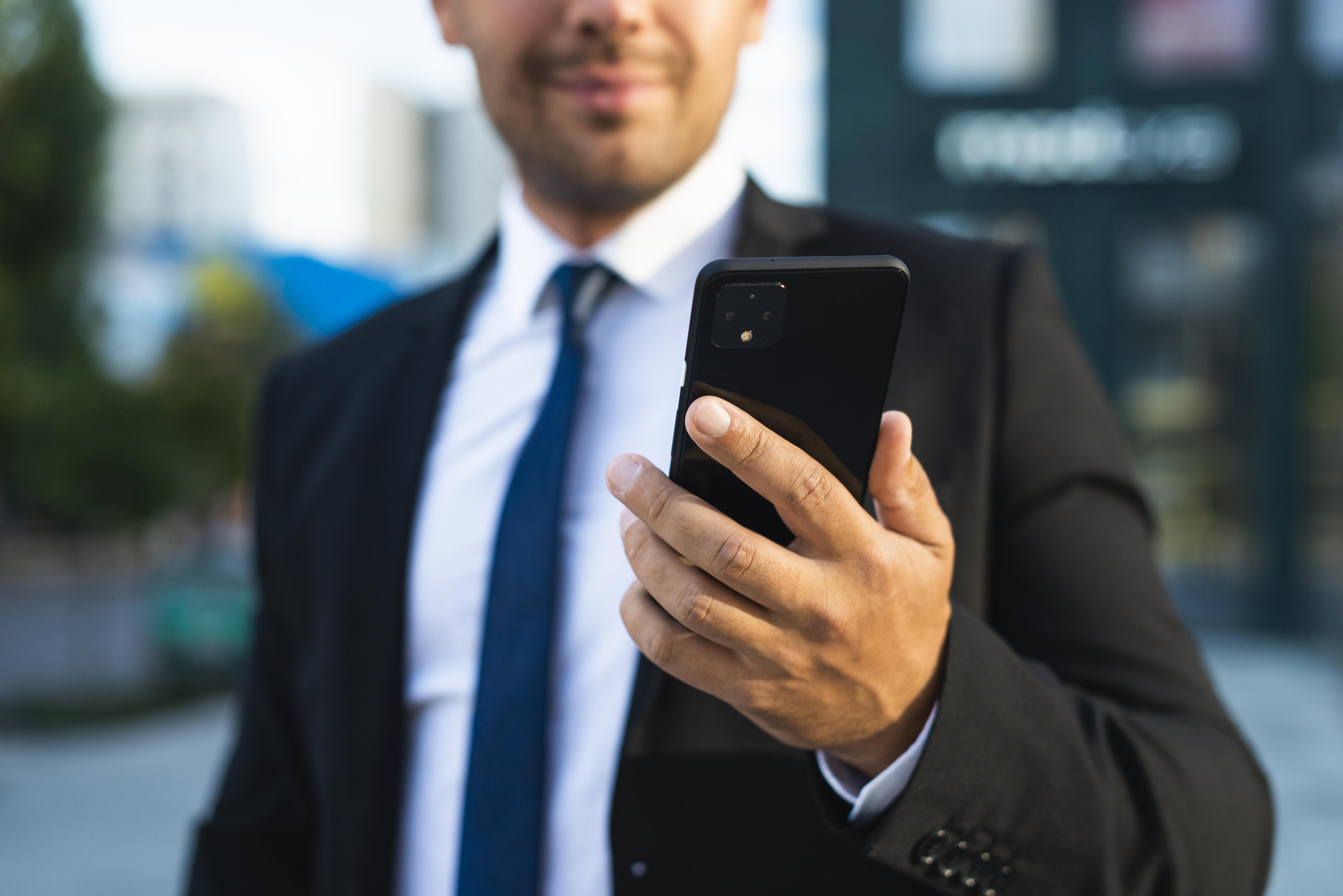 businessman-outdoors-looking-at-his-phone.jpg businessman-outdoors-looking-at-his-phone.jpg